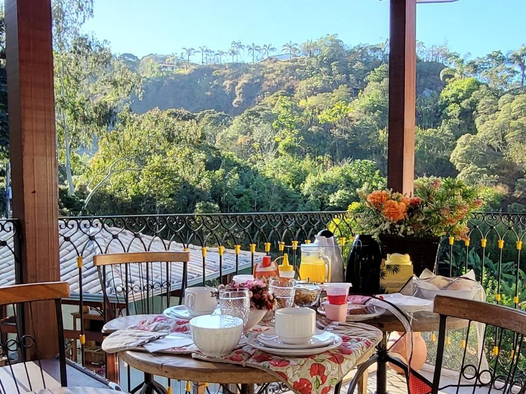 Mesa de café da manhã posta na varanda, com vista para a mata
