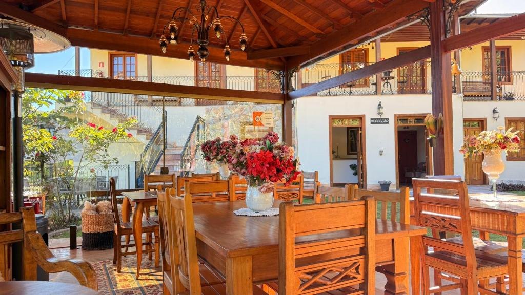 Gazebo de madeira com mesas e flores, de frente para a recepção